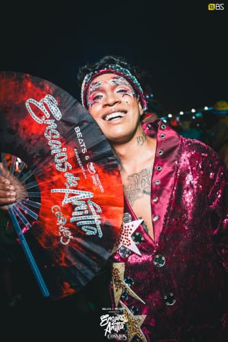 Artista no palco segurando um leque Ensaios da Anitta